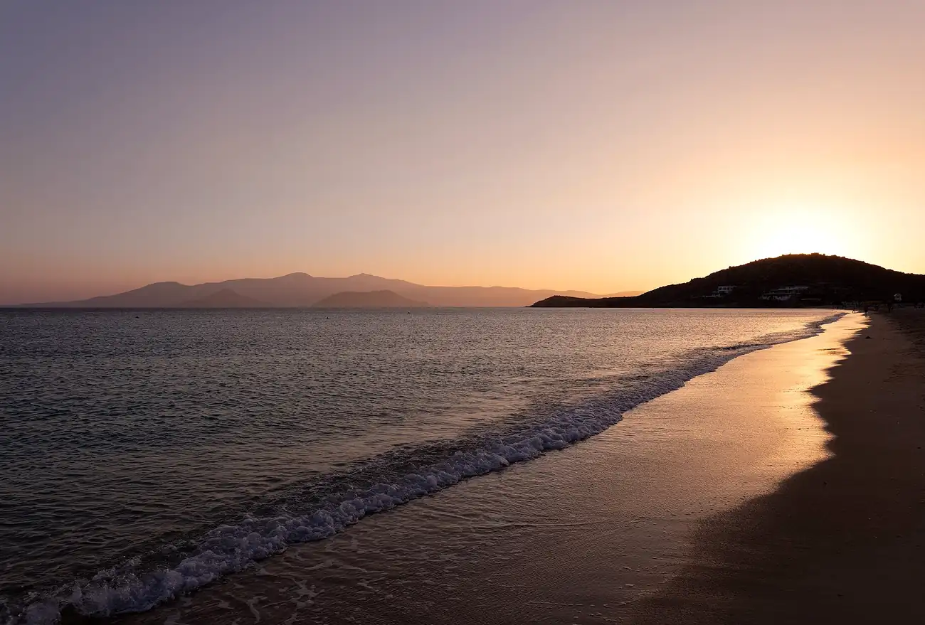 Playa de Agios Prokopios en Naxos al atardecer, con la orilla de arena y el mar tranquilo