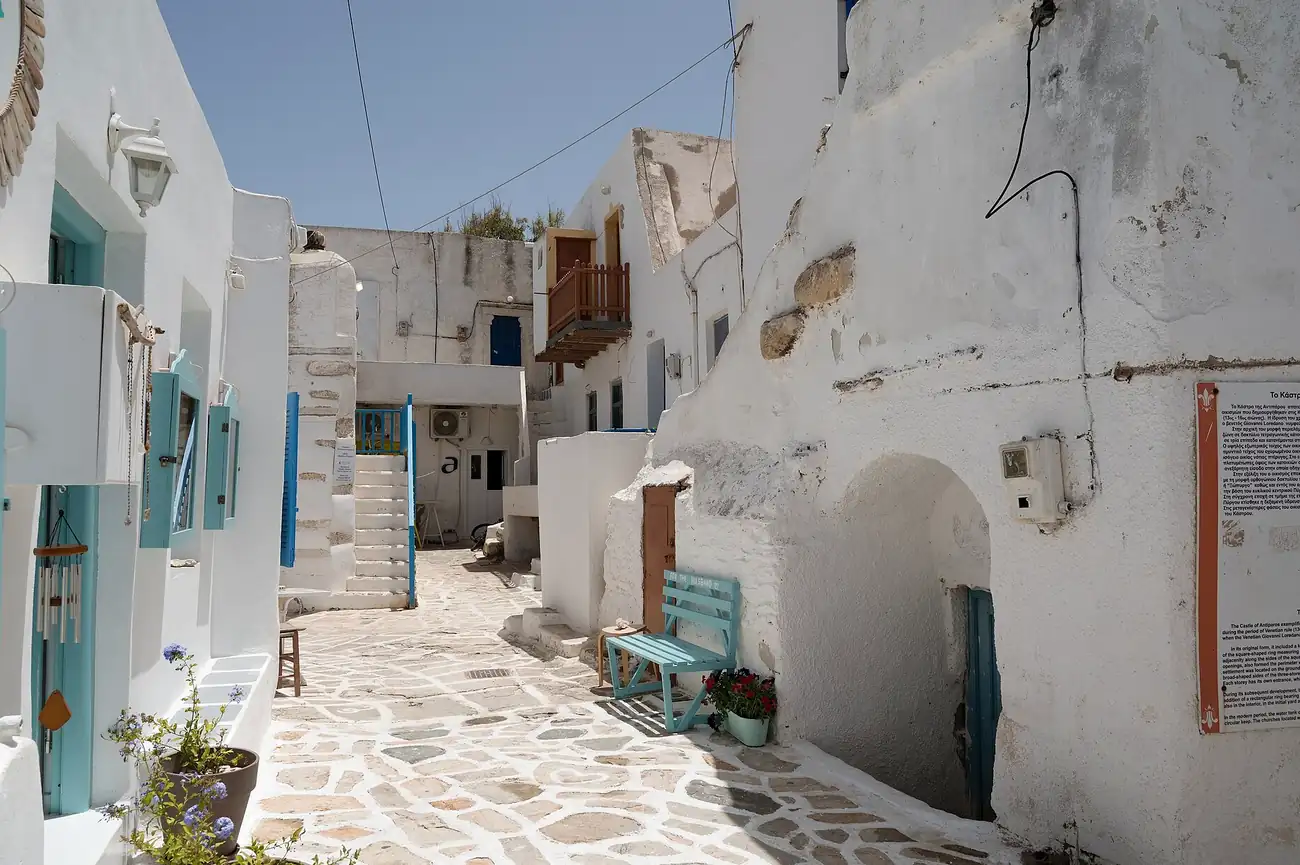 Callejón blanco del castillo de Antiparos con puertas turquesa