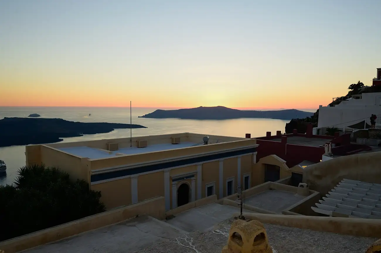 Atardecer sobre la caldera de Santorini visto desde Fira, con el islote volcánico al fondo