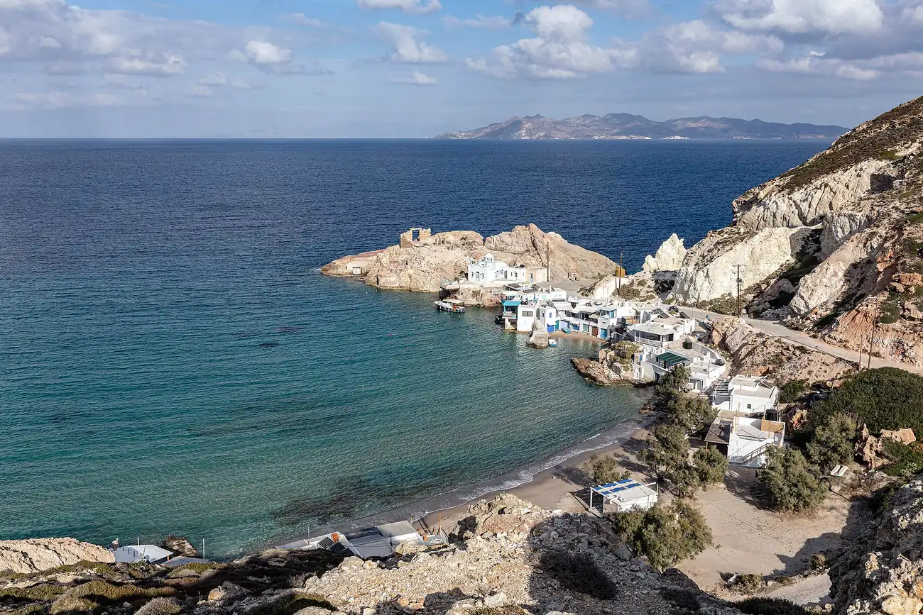 Cala de Firopotamos en Milos con la iglesia blanca en la punta y casas de pescadores