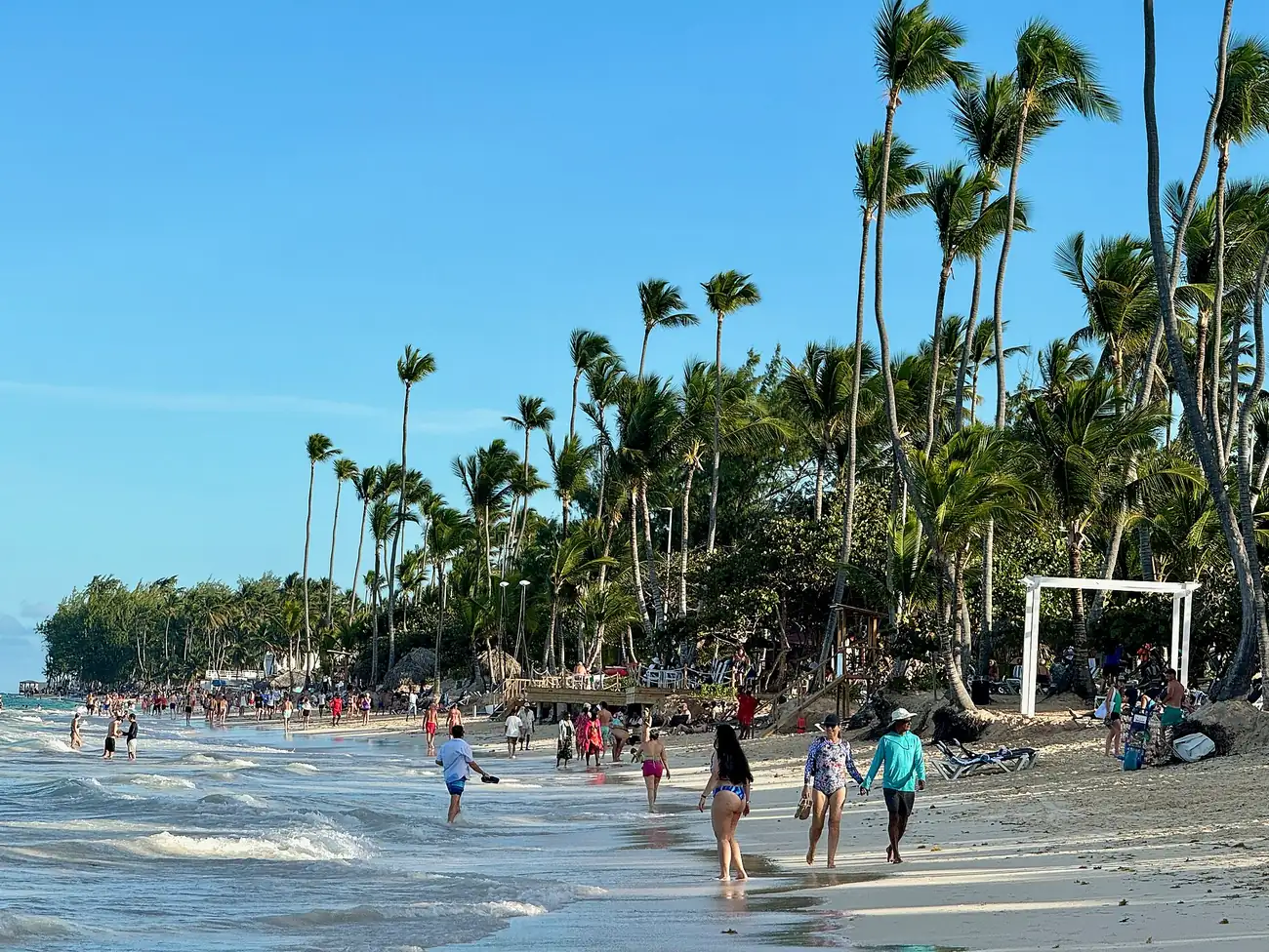 Playa Bávaro en Punta Cana con palmeras y bañistas, uno de los destinos de los paquetes de Flowo