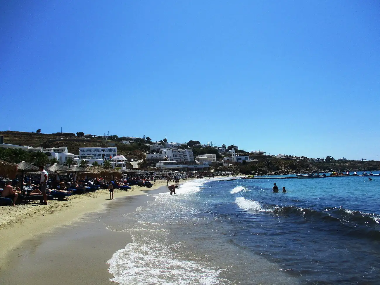 Playa de Platis Gialos en Mykonos con arena dorada, hamacas y agua turquesa