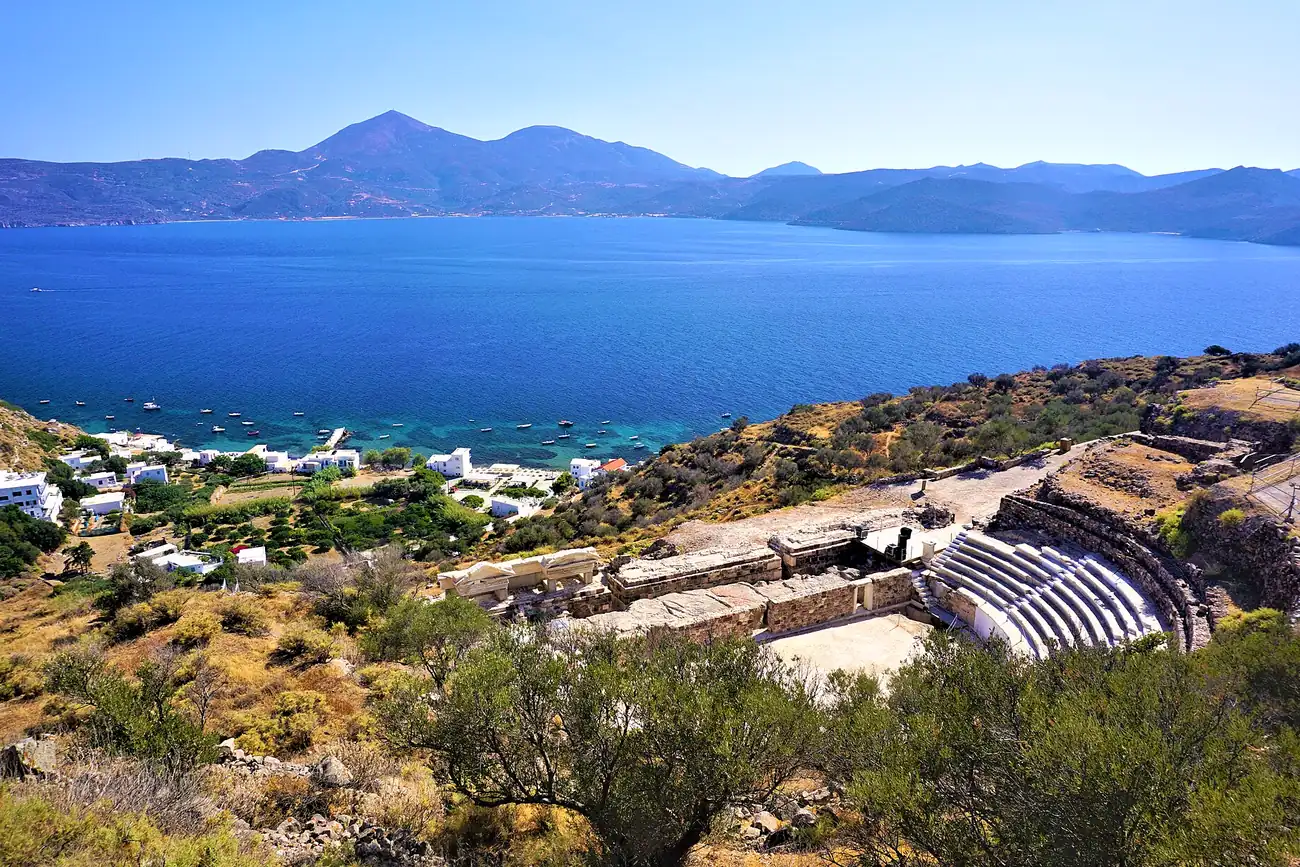 Gradas de mármol del teatro antiguo de Milos con la bahía detrás