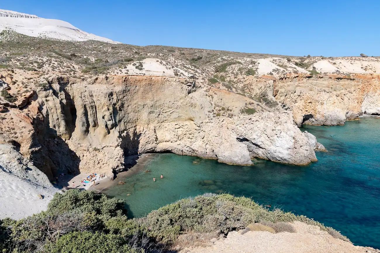 Playa de Tsigrado en Milos, encajada entre acantilados con agua turquesa
